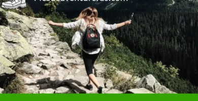 Mujer caminando por una montaña con los brazos alzados, cartel verde con Beneficios del senderismo