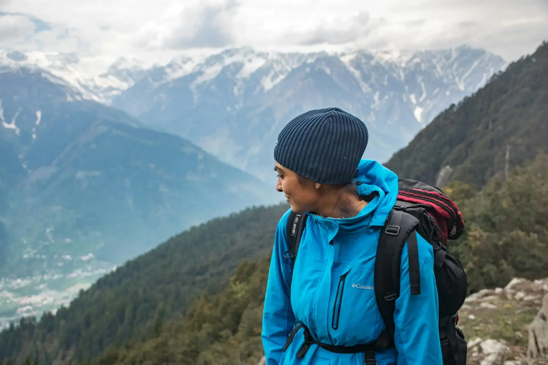 Mujer encima de una montaña viendo hacia atras